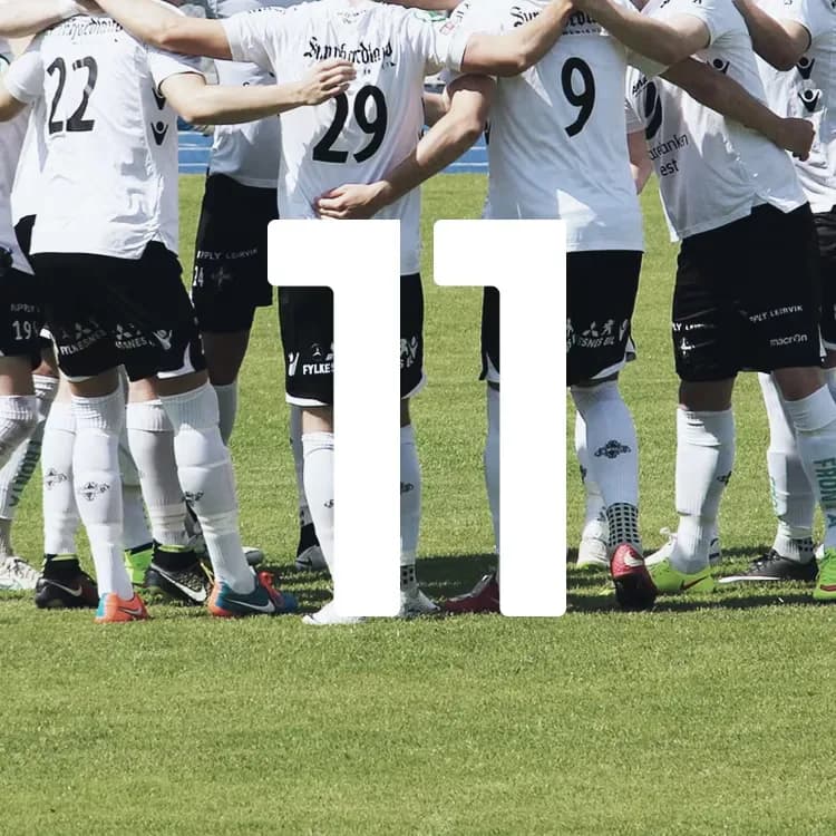 Soccer team in white jerseys huddled on a grassy field, with large white number "11" overlaid in front.