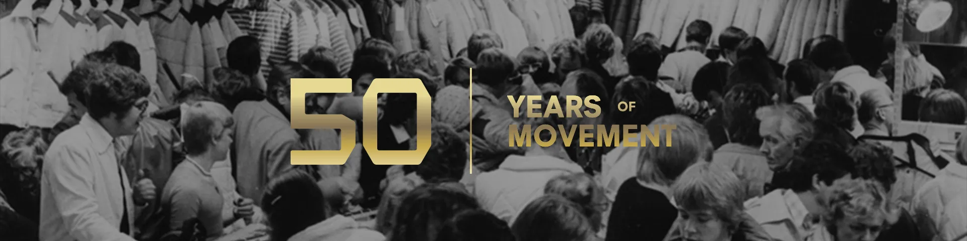 Black and white photo of a crowded gathering with text overlay: "50 Years of Movement" in gold.