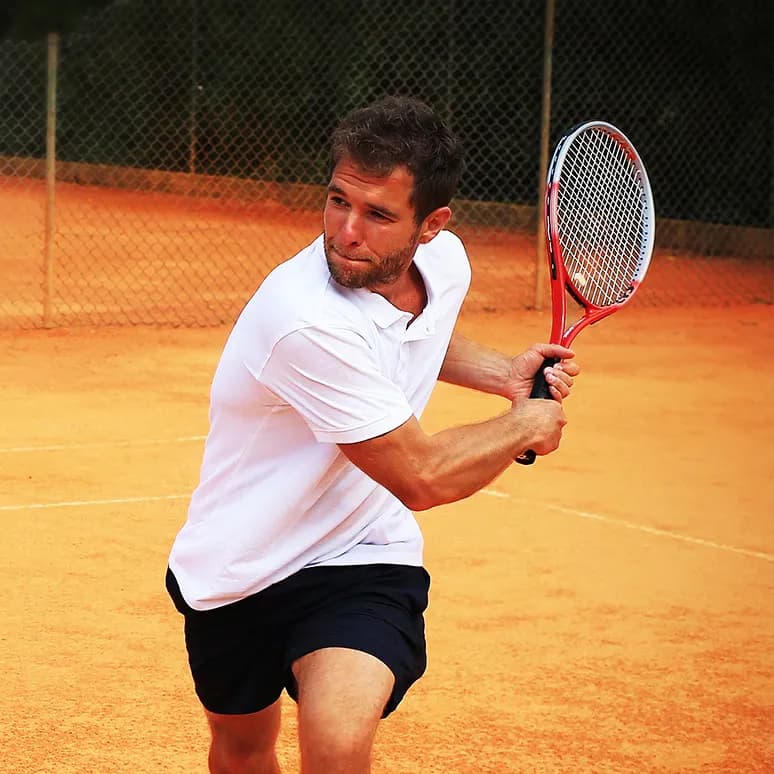 A man playing tennis on a clay court